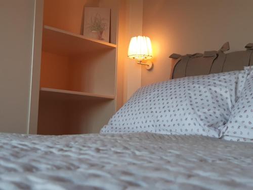 a bedroom with a white bed with a light on it at Agriturismo Fonteregia in Montecatini Terme