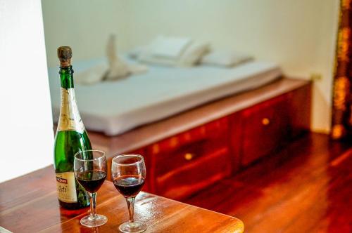 a bottle of wine and two glasses on a table at Camaya-an Paradise Beach Resort in Malabugas