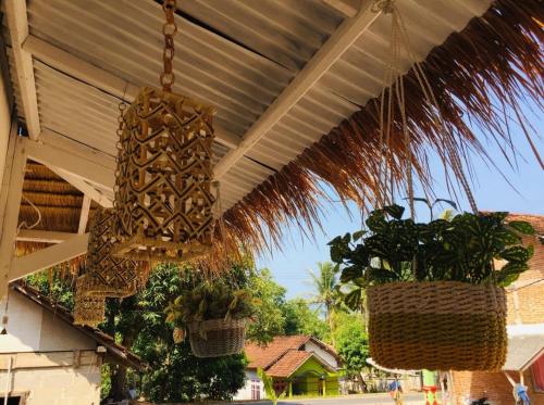 a chandelier hanging from a patio with plants in baskets at Inap.Inap Karimunjawa in Karimunjawa