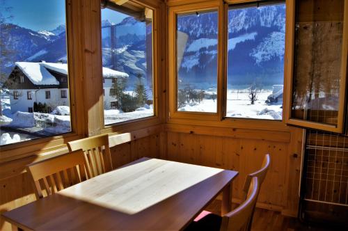 a table and chairs in a room with snowy mountains at Der Ulmenhof in Gosau