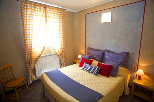 een slaapkamer met een bed met rode en blauwe kussens bij Ca Mè in Monterosso al Mare