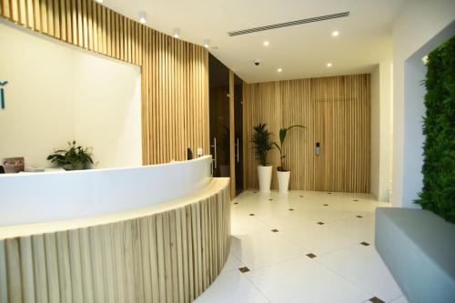 a lobby with a wooden wall and plants at Hai Hotel in Larnaka