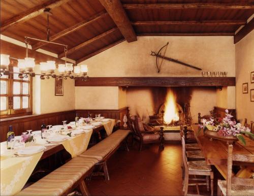 una sala da pranzo con tavoli e camino di Fattoria La Gigliola a Montespertoli