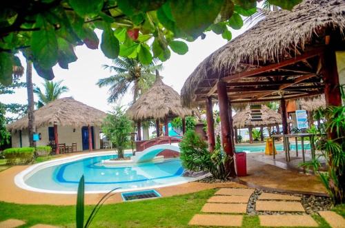 a resort with a swimming pool and a building at Camaya-an Paradise Beach Resort in Malabugas
