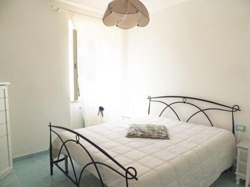 a bedroom with a bed with a white bedspread and a window at Casa Cirilla in Procchio
