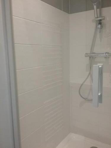 La salle de bains blanche est pourvue d'une douche et de toilettes. dans l'établissement Studio, à Cancale