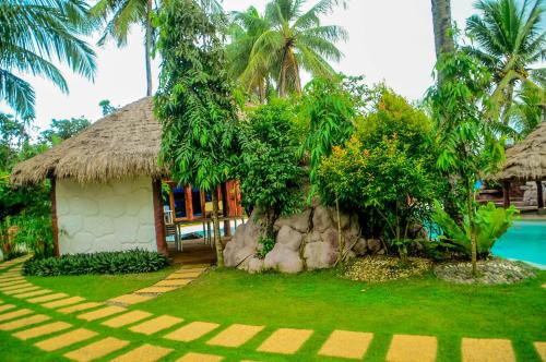 a resort with a building and a swimming pool at Camaya-an Paradise Beach Resort in Malabugas