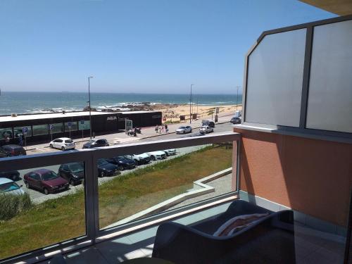 a balcony with a view of a parking lot and the ocean at H2OPorto Beachfront Apartment in Vila Nova de Gaia