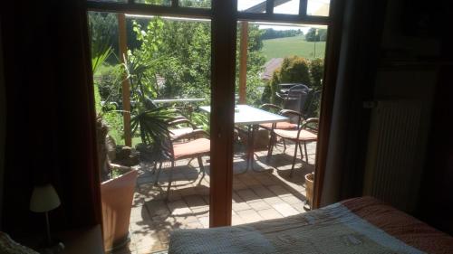 Elle offre une vue sur une terrasse avec une table et des chaises. dans l'établissement Apartment mit Gartenblick, à Eckersdorf