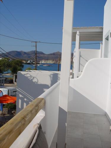 a balcony of a house with a view of the water at Litsa Malli Rooms in Pollonia