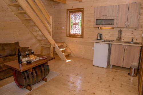 eine Küche und ein Wohnzimmer mit einem Tisch in einer Hütte in der Unterkunft Wood House in Virpazar