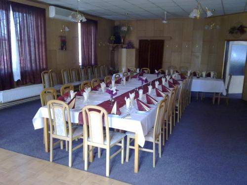 a long table with white tables and chairs in a room at Studánka in Orlová