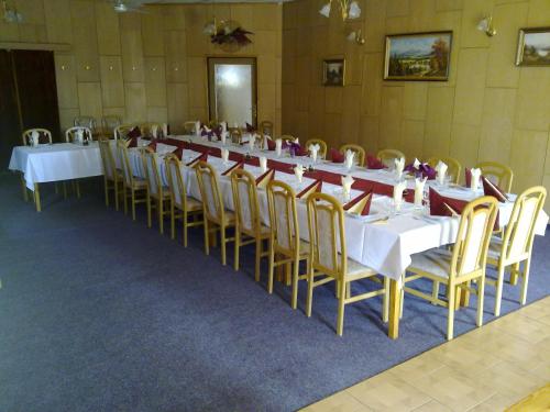 a long table with white tables and yellow chairs at Studánka in Orlová