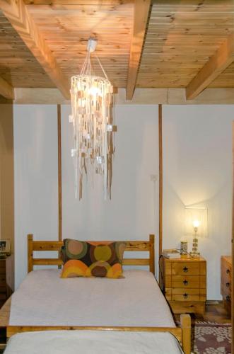 a bedroom with a bed and a chandelier at Casa di Diamanto in Porto Rafti