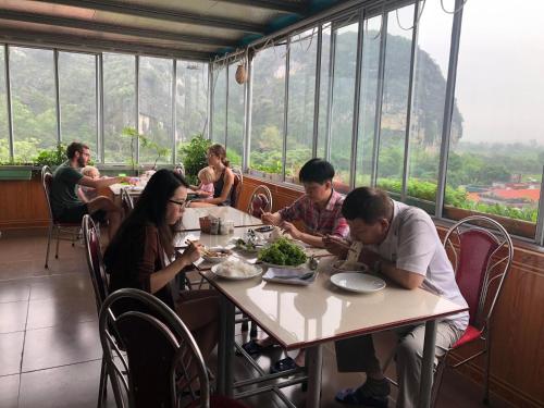 un gruppo di persone sedute a un tavolo in un ristorante di Sierra Homestay a Ninh Binh