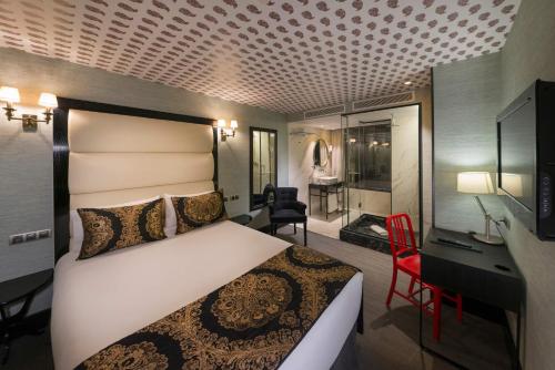 a hotel room with a bed and a desk and a bathroom at Hotel Mirador de Chamartín in Madrid