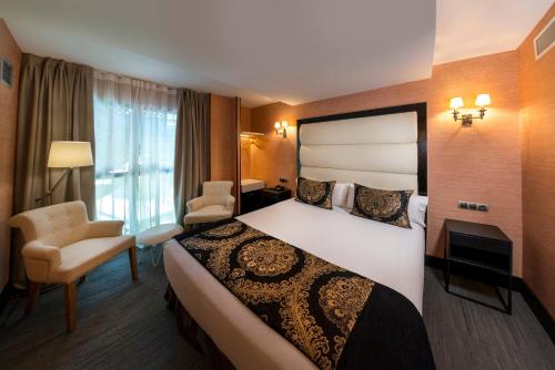 a hotel room with a large bed and a chair at Hotel Mirador de Chamartín in Madrid