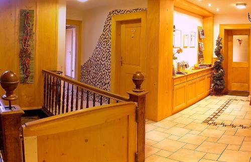 a hallway with a staircase and aoyer with yellow walls at Wildkräuter-Gasthof Linde in Löffingen