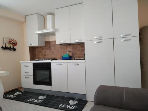 a kitchen with white cabinets and a stove at Aspra al delfino blu in Bagheria