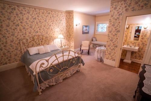 a bedroom with a bed and a chair and a sink at McCloud Hotel in McCloud