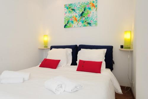 ein weißes Bett mit zwei roten Kissen darauf in der Unterkunft Le Savoy Palace - Five Stars Holiday House in Nizza
