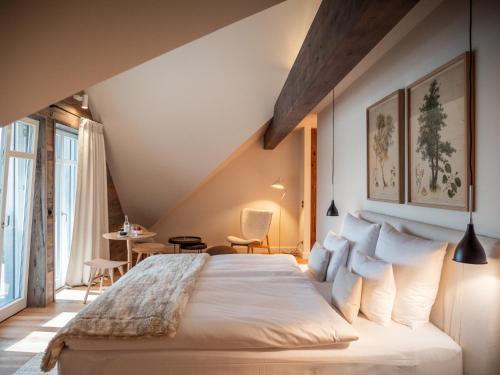 a bedroom with a large bed and a table at Alpenloge Design Hotel in Scheidegg