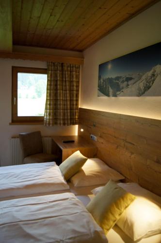 a hotel room with two beds and a window at Pension Hohe Salve in Westendorf