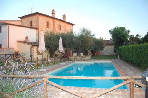 a swimming pool in front of a house at Agriturismo Podere Ranciano Alto in Castiglione del Lago