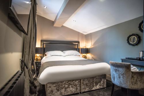 a bedroom with a large bed and a chair at N'ista Boutique Rooms Birkdale - Southport in Southport