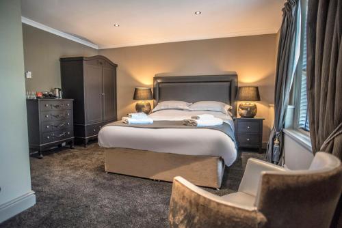a bedroom with a large bed and a chair at N'ista Boutique Rooms Birkdale - Southport in Southport