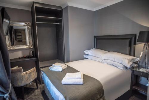 a bedroom with a bed with towels on it at N'ista Boutique Rooms Birkdale - Southport in Southport