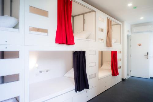 een kamer met witte muren en rode gordijnen bij Good People Design Hostel in Belgrado