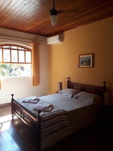 Un dormitorio con una cama con techo de madera. en Pousada da Figueira, en Conservatória