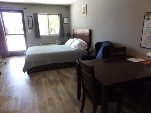 1 dormitorio con cama, escritorio y mesa en Big Spirit Resort, en Spirit Lake