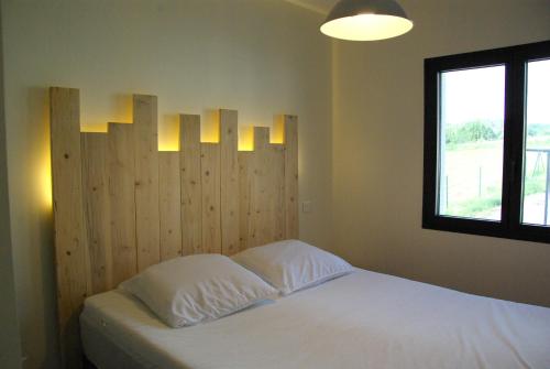 a bedroom with a bed with a wooden headboard at Gîte entre mer et montagne in Laa-Mondrans