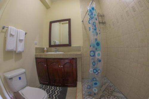 a bathroom with a shower and a toilet and a sink at Solet's Paradise Negril in Negril