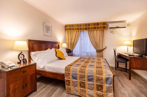 a bedroom with a bed and a desk with a telephone at Park Plaza Apartments in Santiago