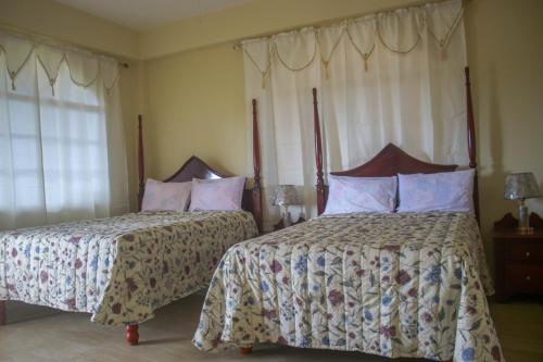 two beds in a bedroom with two at Solet's Paradise Negril in Negril