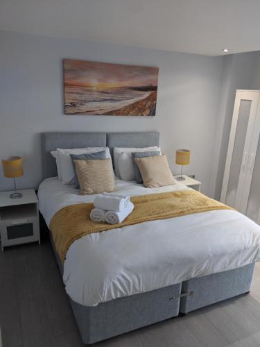 a bedroom with a large bed with a painting on the wall at LT Grove Apartment - Stratford in London