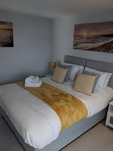 a large bed with two towels on top of it at LT Grove Apartment - Stratford in London