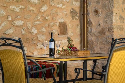a table with a bottle of wine and two glasses at Villa Zacharenia in Nikiana