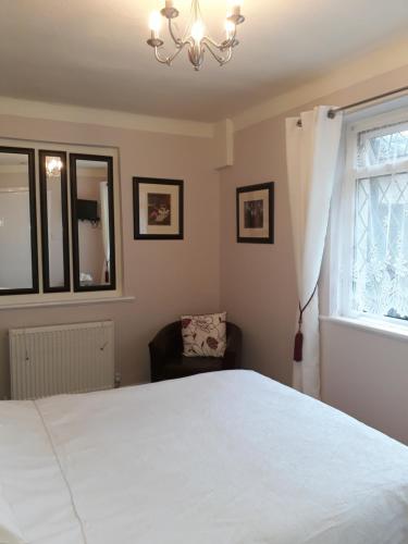 a bedroom with a large white bed and a window at Plas Tirion in Llanddulas