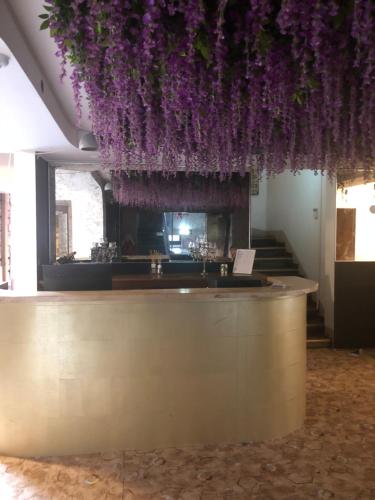 un bar con flores púrpuras colgando del techo en Villa Kadriorg Hostel en Tallin