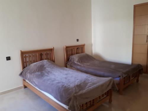 Duas camas individuais sentadas num quarto sem um divã em Dar Lazraq em Sidi Rahal