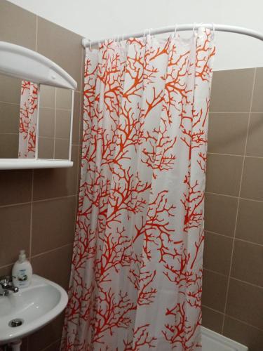 a shower curtain in a bathroom with a sink at Véndektanya Vendégház in Tapolca