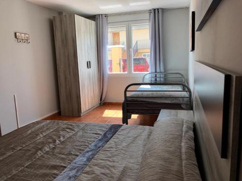 a small bedroom with two beds and a window at Casa Pareada en Peñiscola in Peñíscola
