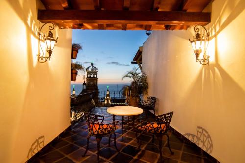 a balcony with a table and chairs and a view of the ocean at BellView Hotel Boutique in Puerto Vallarta