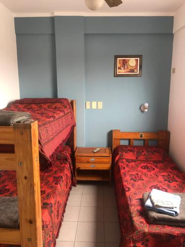 una piccola stanza con due letti e un comodino di Hostal del Milagro a Salta