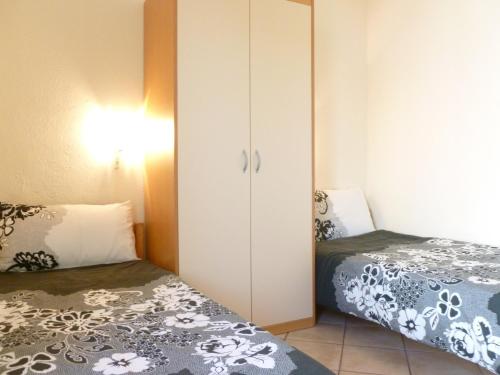 a small bedroom with two beds and a closet at Luna Apartments in Trogir