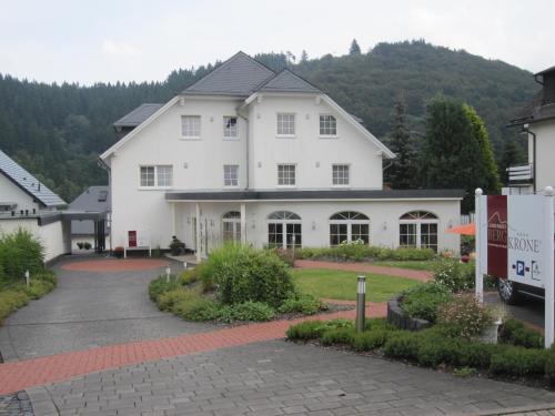 a white house with a sign in front of it at Landhaus Bergkrone in Willingen